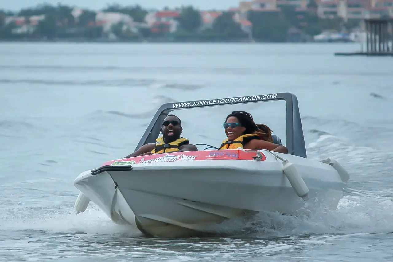 A happy couple traveling on a speedboat in light rain
