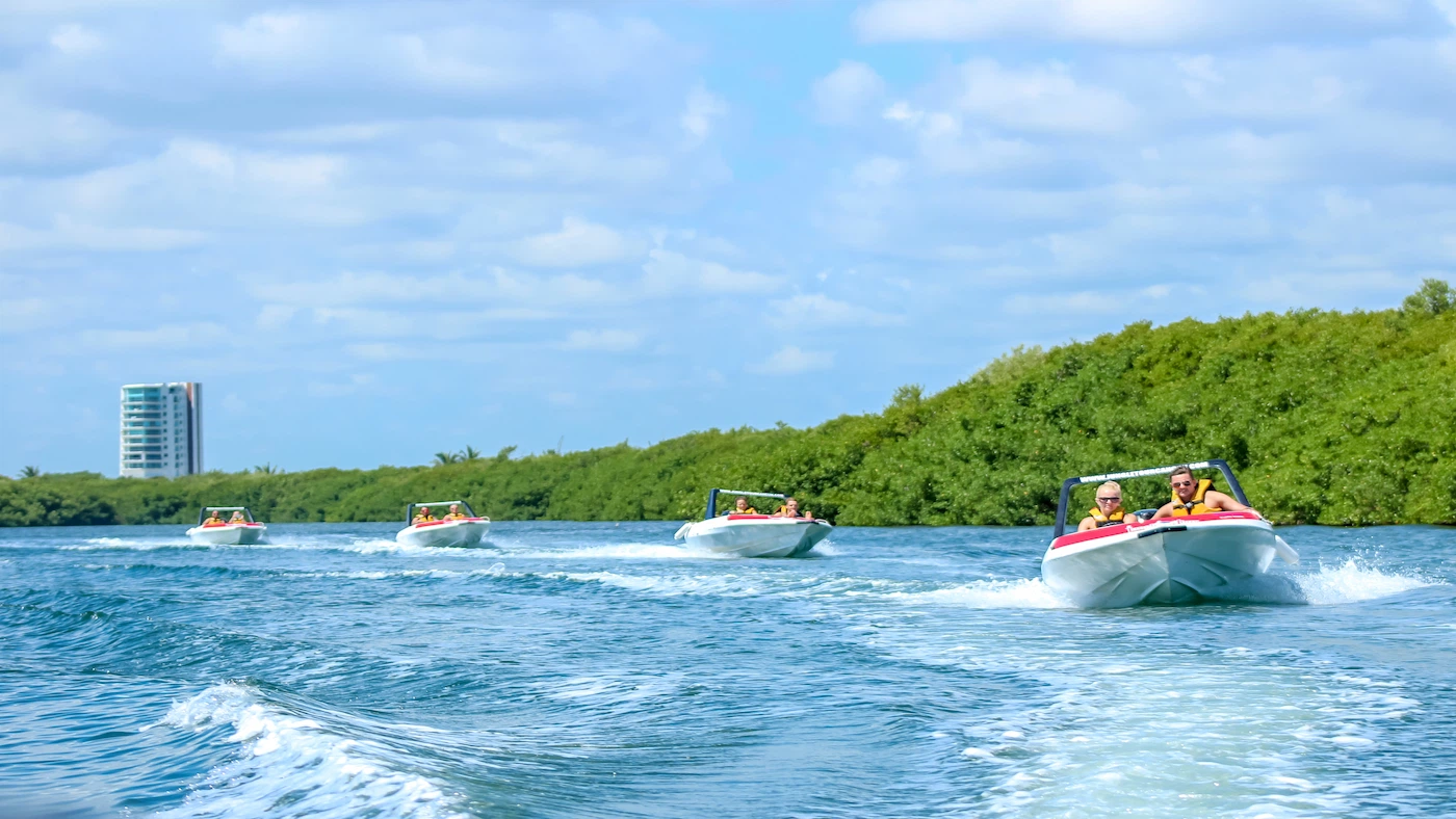 a woman driving a Jungle Tour Adventure speedboat, forming a caravan of four speedboats through the channels of the lagoon.